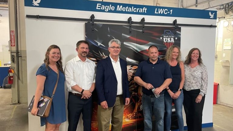 Congressman-Brandon-Williams-third-from-left-poses-with-Eagle-Metalcraft-owner-Michael-Bower-second-from-left-and-success-team-members-Justyna-left-Jim-Erin-and-Cindy