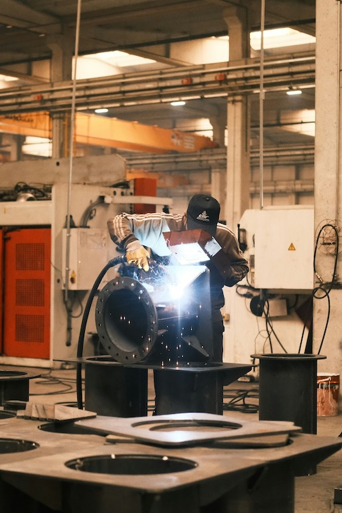 metal fabrication worker finishing up metal drum